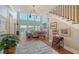 The gorgeous living room showcases high ceilings, a stone fireplace, and expansive windows with views of the water at 1543 Eastbrook Dr, Sarasota, FL 34231