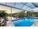 Serene screened-in pool area featuring an inviting pool, outdoor dining, and scenic water views at 1543 Eastbrook Dr, Sarasota, FL 34231
