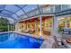 Inviting screened-in pool area with comfortable seating, ceiling fans, and views of the backyard at 1543 Eastbrook Dr, Sarasota, FL 34231