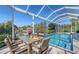 Relaxing screened-in pool area with an outdoor dining table, overlooking a scenic view of the water at 1543 Eastbrook Dr, Sarasota, FL 34231