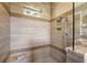 Modern shower featuring beautiful stone tilework, a built-in seat, and convenient recessed shelving at 1543 Eastbrook Dr, Sarasota, FL 34231
