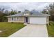 Charming single-story home featuring a two-car garage, a blue front door, and neutral-colored stucco at 1620 Geranium Ave, North Port, FL 34288