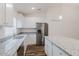 Bright kitchen featuring white cabinets, stainless steel appliances, and a center island with a granite countertop at 1620 Geranium Ave, North Port, FL 34288