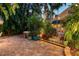 Backyard at dusk featuring mature tropical landscaping, a hot tub, and a patio area at 1631 Loma Linda St, Sarasota, FL 34239