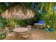 Outdoor patio with hot tub and thatched umbrella with dining table at 1631 Loma Linda St, Sarasota, FL 34239