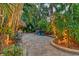 Secluded backyard patio featuring a spa and dining area surrounded by tropical foliage and lighting at 1631 Loma Linda St, Sarasota, FL 34239