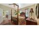 Bright bedroom featuring a dark wood four-poster bed, ceiling fan, and doorway leading to another room at 1631 Loma Linda St, Sarasota, FL 34239