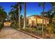 Beautiful vintage home at dusk with lush landscaping, a brick driveway, and a detached garage at 1631 Loma Linda St, Sarasota, FL 34239