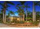 Charming yellow house surrounded by lush tropical plants and blue shutters at twilight at 1631 Loma Linda St, Sarasota, FL 34239