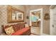 View of the hallway with a ornate mirror, bench, and access to the kitchen at 1631 Loma Linda St, Sarasota, FL 34239