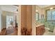 Hallway view leading to an ensuite bathroom with decorative wallpaper and neutral tile accents at 1631 Loma Linda St, Sarasota, FL 34239