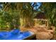 Backyard hot tub at night with illuminated landscaping and a tiki hut at 1631 Loma Linda St, Sarasota, FL 34239