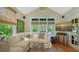 Cozy living room with a large sectional sofa, glass coffee table, large windows and a TV for entertainment at 1631 Loma Linda St, Sarasota, FL 34239