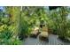 Relaxing patio features two lounge chairs surrounded by tropical plants and bamboo at 1631 Loma Linda St, Sarasota, FL 34239