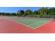 Wide angle shot of outdoor tennis courts surrounded by a fence and a lush green area under a clear blue sky at 1631 Loma Linda St, Sarasota, FL 34239