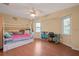 Well-lit bedroom with a decorative ceiling fan, bunk beds, and two windows at 17368 Norseman Ave, Port Charlotte, FL 33948