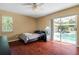Cozy bedroom with ceiling fan, dark wood floors, and sliding glass doors to the pool at 17368 Norseman Ave, Port Charlotte, FL 33948