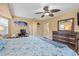 Bright bedroom features a large bed, ceiling fan, and rustic wood dresser with mirror at 17368 Norseman Ave, Port Charlotte, FL 33948