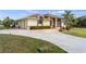 Attractive single-story home featuring a two-car garage, arched windows, and lush landscaping at 17368 Norseman Ave, Port Charlotte, FL 33948