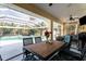 Outdoor dining area under a screened enclosure with a view of the pool and lush landscaping at 17368 Norseman Ave, Port Charlotte, FL 33948