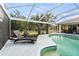 Sparkling screened-in pool with lounge chairs and a serene backyard setting at 17368 Norseman Ave, Port Charlotte, FL 33948