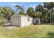 Large storage shed on a grassy lawn with mature trees providing privacy at 17368 Norseman Ave, Port Charlotte, FL 33948