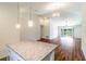 Open floor plan with kitchen island, wood flooring, vaulted ceilings and sliding glass doors to yard at 1864 Nardello Ave, North Port, FL 34288