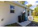 Side exterior with a white painted wall, modern window fixtures and utilities neatly arranged at 2307 Homestead Cir, North Port, FL 34286