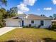 Charming single-story home featuring a two car garage, blue front door, and fresh landscaping at 2307 Homestead Cir, North Port, FL 34286