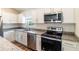 Modern kitchen featuring stainless steel appliances, granite countertops, and white cabinets at 2307 Homestead Cir, North Port, FL 34286