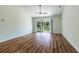 Bright living room features wood-look floors, a ceiling fan, and sliding glass doors to the backyard at 2307 Homestead Cir, North Port, FL 34286