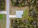 Aerial view of a home with a grey roof, surrounded by lush greenery and a driveway at 3267 N Chamberlain Blvd, North Port, FL 34286
