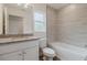 Bathroom showcasing granite vanity, toilet, and tiled tub with shower at 3267 N Chamberlain Blvd, North Port, FL 34286