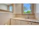 A powder room featuring a vanity with a granite countertop and a view of tropical foliage from the window at 3491 Bayou Sound, Longboat Key, FL 34228