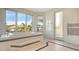Bright bathroom featuring a soaking tub beneath a large window with steps leading up to the tub at 3491 Bayou Sound, Longboat Key, FL 34228