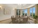 Bright dining room with round table set, beige chairs, and large windows overlooking the water at 3491 Bayou Sound, Longboat Key, FL 34228