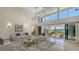 This stylish living room with large windows offers an exquisite chandelier and an outdoor view of the water at 3491 Bayou Sound, Longboat Key, FL 34228