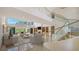 Bright living room with a fireplace, elegant staircase, and floor to ceiling windows overlooking a patio at 3491 Bayou Sound, Longboat Key, FL 34228