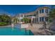 Beautiful pool area with a tropical landscape that complements this luxury waterfront home with balconies and steps to patio at 3491 Bayou Sound, Longboat Key, FL 34228