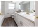Bright bathroom features white vanity, countertop, and wood-look flooring at 353 Hillview Rd, Venice, FL 34293