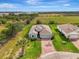 An aerial shot of a one-story home featuring a brick driveway, a lawn, and mature landscaping at 3631 Pebble Ter, Punta Gorda, FL 33980