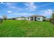 View of the home's backyard with a screened-in lanai and spacious, green lawn at 3631 Pebble Ter, Punta Gorda, FL 33980