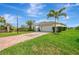 Lovely one-story home featuring lush landscaping, a two-car garage, and a brick driveway under blue skies at 3631 Pebble Ter, Punta Gorda, FL 33980