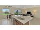 Kitchen island sink with stainless steel faucet adjacent to the breakfast nook and living room at 3631 Pebble Ter, Punta Gorda, FL 33980