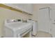 This laundry room has a washer and dryer and white cabinets at 3631 Pebble Ter, Punta Gorda, FL 33980