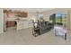 Open-concept living space with a gray sofa, breakfast bar, and dining table at 3631 Pebble Ter, Punta Gorda, FL 33980