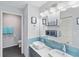 Bright bathroom with double sinks, blue tile backsplash, and modern fixtures at 4240 Marseilles Ave # 3248, Sarasota, FL 34233