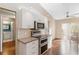 Bright kitchen featuring stainless steel appliances, white cabinets, and hardwood flooring at 4240 Marseilles Ave # 3248, Sarasota, FL 34233