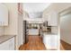 Bright kitchen features white cabinets, stainless steel appliances, stone countertops and wood flooring at 4240 Marseilles Ave # 3248, Sarasota, FL 34233