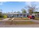 Charming single-story home with a well, solar panels, red SUV and a small motorcycle in the front yard at 450 Dalton Blvd, Port Charlotte, FL 33952